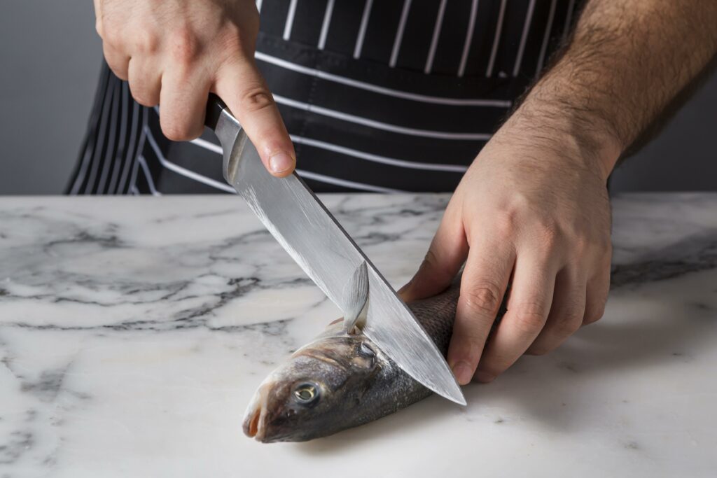 Mareyeur découpant un poisson frais SNAM Alpes Marée